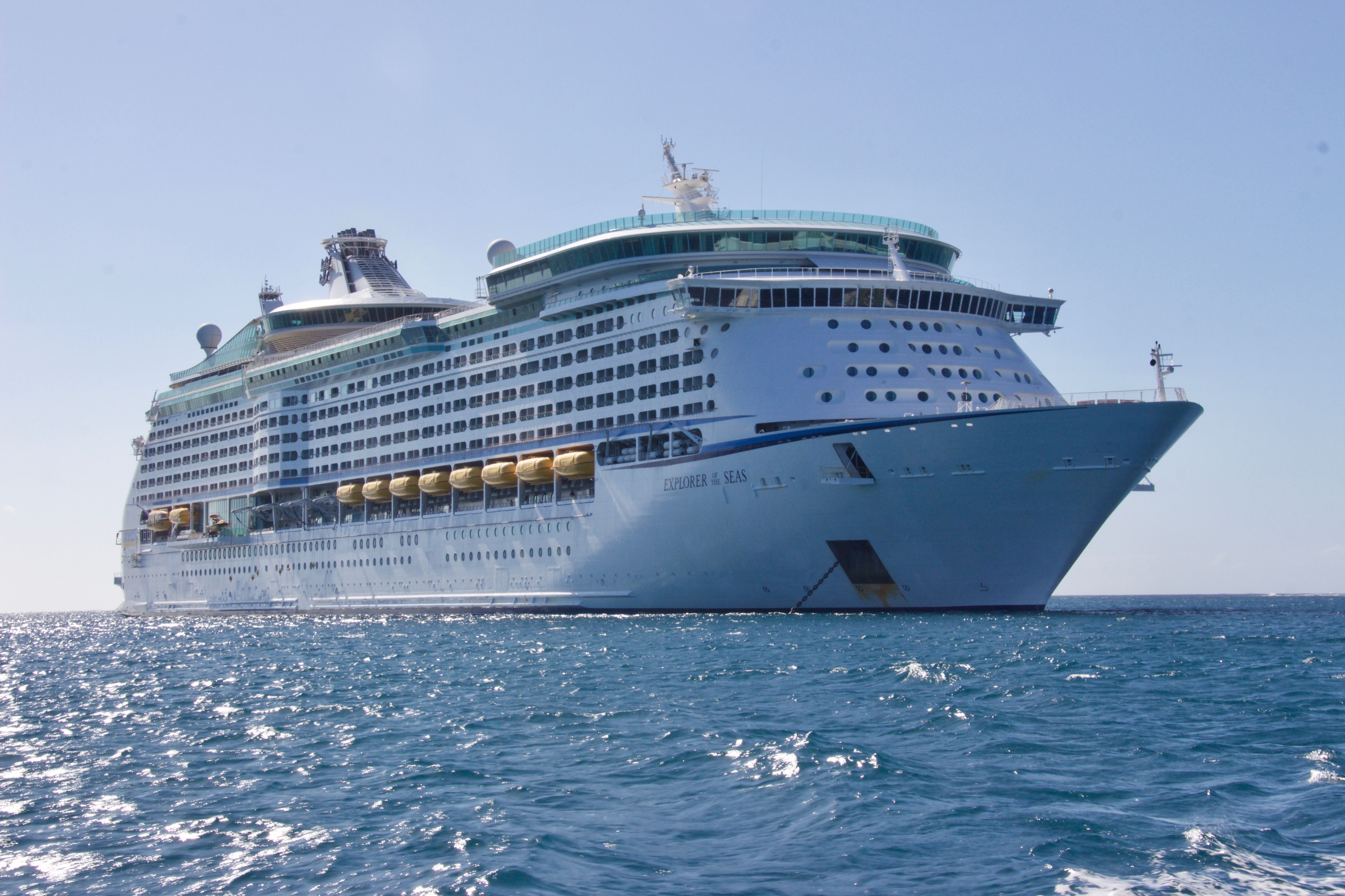 A white cruise ship sailing under a clear blue sky